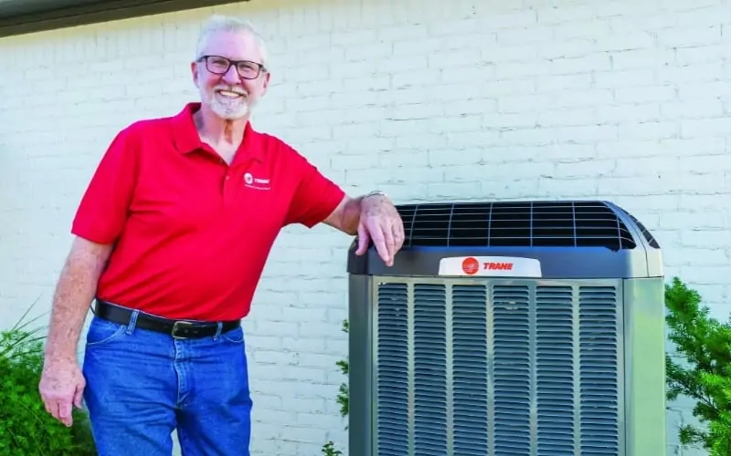 trane employee standing with ac unit